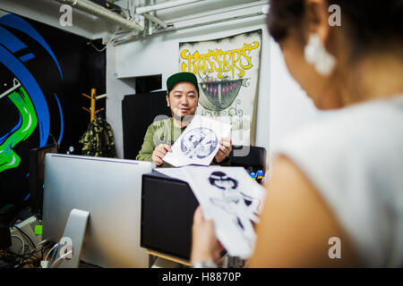 Two people, designers working in a small business, looking at illustrations. Stock Photo