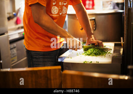 The ramen noodle shop. A chef chopping vegetables. Stock Photo