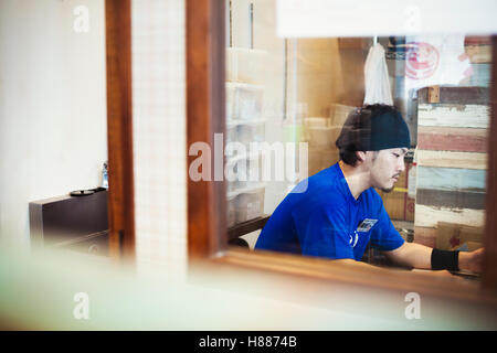The ramen noodle shop. A chef sitting in a kitchen. Stock Photo