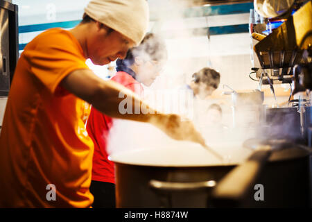 The ramen noodle shop. A chef stirring a huge pot of noodles cooking. Stock Photo