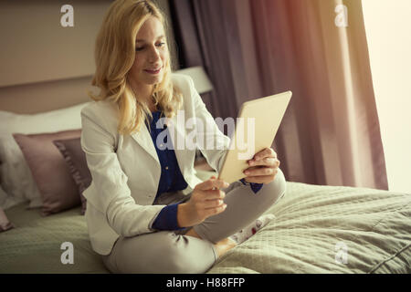 Businesswoman using tablet at home  in bed Stock Photo