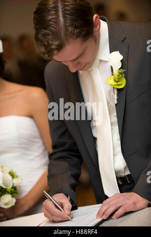 Civil ceremony, groom signing a marriage certificate at the registry office Stock Photo