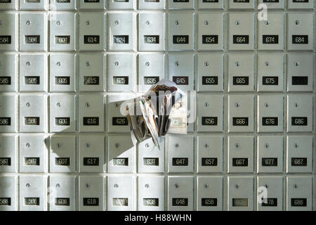 Post Office box overflowing with junk mail Stock Photo