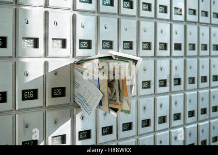 Post Office box overflowing with junk mail Stock Photo