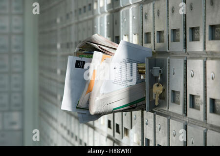 Post Office box overflowing with junk mail Stock Photo