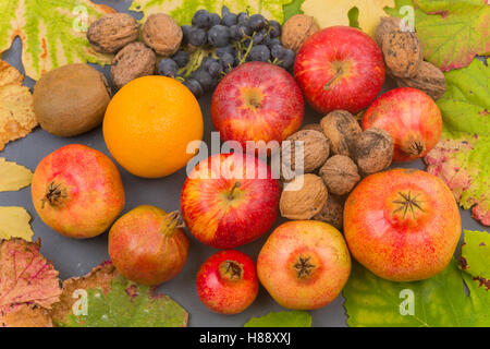 Autumn fruits still life among leaves on wooden table Stock Photo