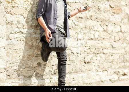 man with earphones and smartphone on street Stock Photo