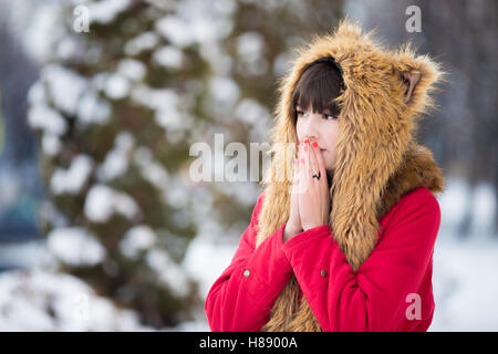 Woman shivering from cold outdoors in wintertime Stock Photo