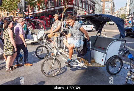 Rickshaw or pedicab drivers waiting for tourists at Leicester Square in London, England United Kingdom UK Stock Photo