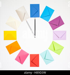 Twelve envelopes isolated on white background. Clock of colored envelopes for Christmas mailing. Stock Photo