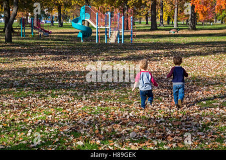 Detroit, Michigan - Two- and three-year-old toddlers run towards a playground on Belle Isle. Stock Photo