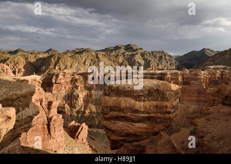 Couple taking selfie at sunset on top of Hoodoo with balancing rock at Charyn Canyon Kazakhstan Stock Photo