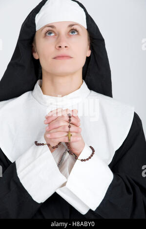 Nun praying the rosary Stock Photo