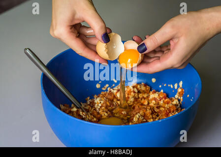 hand pours out raw egg of the shell Stock Photo