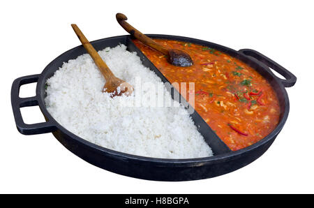 Pork goulash and boiled rice are made in a huge frying pan for the big company. Isolated Stock Photo