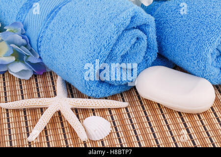Blue towels with flowers and soap, starfish closeup picture. Stock Photo