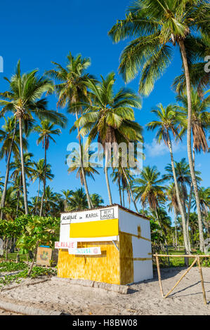 BAHIA, BRAZIL - FEBRUARY 11, 2016: Rustic Brazilian beach shack boarded up under palm trees on an empty beach. Stock Photo