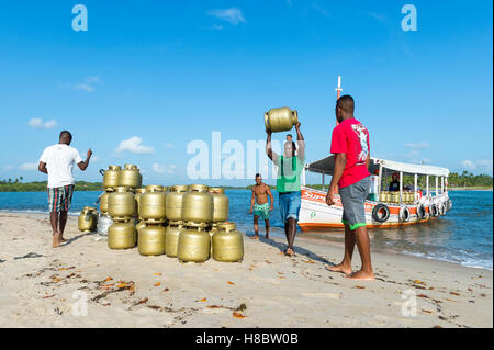 BAHIA, BRAZIL - FEBRUARY 6, 2016: Brazilian men transferring canisters of gas from a boat onto the shore of a remote island. Stock Photo