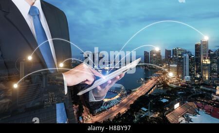 Double exposure of businessman using digital tablet pc with network connection of Singapore city. Network connection concept Stock Photo