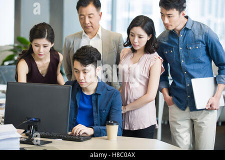 Chinese business people working together with computer Stock Photo
