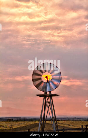 Windmill spinning in the morning glow of the sunrise. Stock Photo