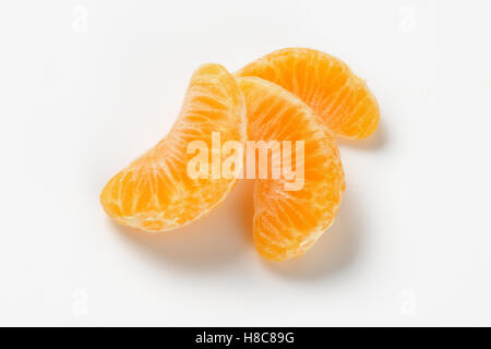 three separated segments of tangerine on white background Stock Photo