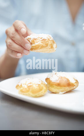 Woman eating eclairs at home. Vertical photos Stock Photo