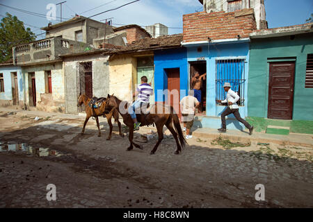 A Cuban cowboy guarjiro chases after his wayward horse in the back streets of Trinidad Cuba Stock Photo