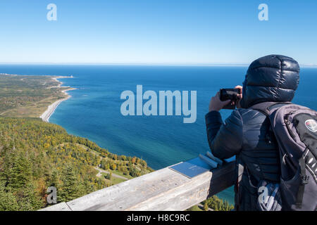 Tourist looking at Cap-des-Rosiers from Mont-St-Alban viewpoint in Forillon National Park, Gaspe Peninsula, Quebec, Canada Stock Photo