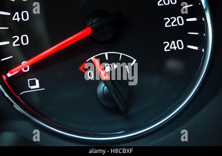 Fuel gauge mounted in round modern car speedometer shows low level of gasoline Stock Photo