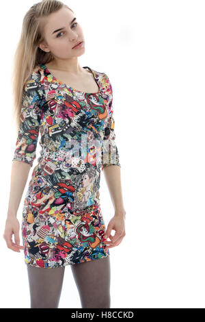 Serious Looking Relaxed Girl Wearing a Short Patterned Mini Dress Against a White Background Stock Photo