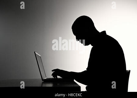 hacker criminal dark web code malware exploit ddos attack infect silhouette contrast Stock Photo