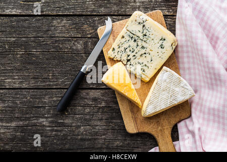 Different kinds of cheeses on old wooden table. Top view. Stock Photo