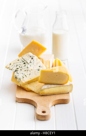Different kinds of cheeses on white wooden table. Stock Photo