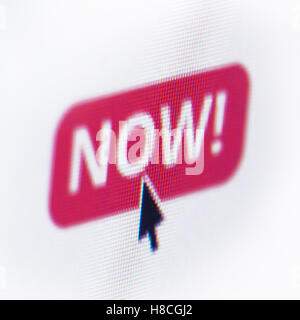 close up of computer screen with red button the text now and a mouse cursor over Stock Photo