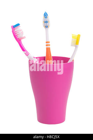 purple glass with three toothbrushes.a family. isolated on white background Stock Photo