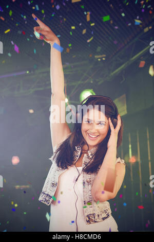 Composite image of portrait of female dj having fun while listening music on headphone Stock Photo