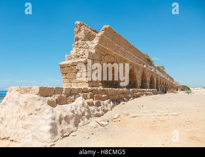 Ancient Roman aqueduct on a sea coast in Maritima National Park in Caesarea, Israel Stock Photo