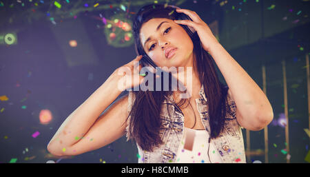 Composite image of portrait of female dj listening music on headphone Stock Photo