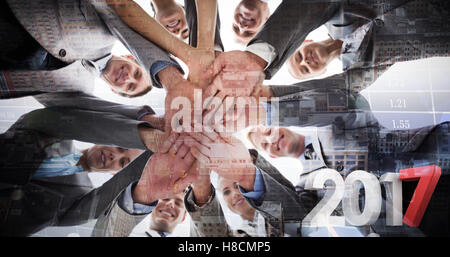 Composite image of smiling business team standing in circle hands together Stock Photo