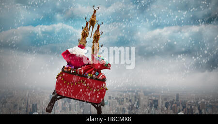 Composite image of rear view of santa claus riding on sled Stock Photo
