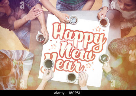 People drinking coffee around new year message Stock Photo