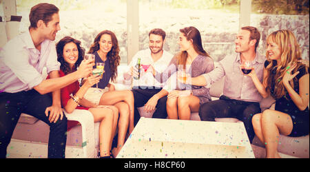 Composite image of friends talking and having drinks Stock Photo
