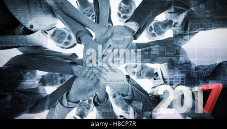 Composite image of smiling business team standing in circle hands together Stock Photo