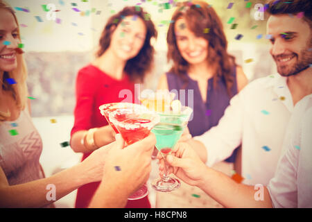 Composite image of cropped image of hand toasting cocktail Stock Photo