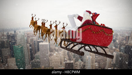 Composite image of santa claus riding on sled during christmas Stock Photo