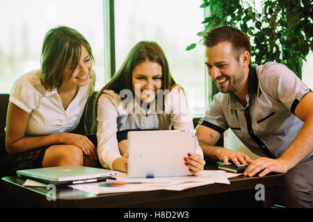three colleagues at the office taking selfies sitting on the couch Stock Photo