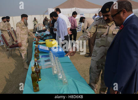 Lahore, Pakistan. 10th Nov, 2016. Pakistani paramilitary soldiers, anti-narcotics force (ANF) and students check the seized wine before crashing and burning them. Pakistani authorities torched tonnes of seized drugs like heroin, hashish, cocaine, liquor and opium during an annual drug burning ceremony attended by anti-narcotics and other officials. Pakistan annually seizes huge quantities of drugs which straddle a route from neighboring Afghanistan, destined for lucrative markets in the Middle East. Credit:  Rana Sajid Hussain/Pacific Press/Alamy Live News Stock Photo
