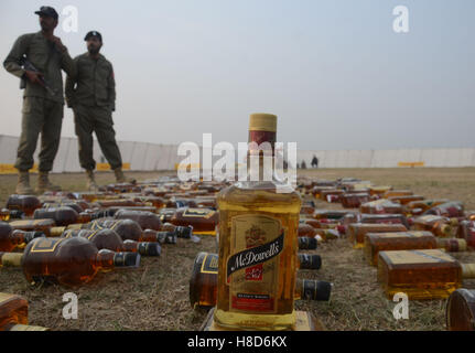 Lahore, Pakistan. 10th Nov, 2016. Pakistani paramilitary soldiers, anti-narcotics force (ANF) and students check the seized wine before crashing and burning them.Pakistani authorities torched tonnes of seized drugs like heroin, hashish, cocaine, liquor and opium during an annual drug burning ceremony attended by anti-narcotics and other officials.P akistan annually seizes huge quantities of drugs which straddle a route from neighboring Afghanistan, destined for lucrative markets in the Middle East. Credit:  Rana Sajid Hussain/Pacific Press/Alamy Live News Stock Photo
