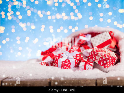 Christmas background with pile of gifts in Santa bag, placed on snow Stock Photo